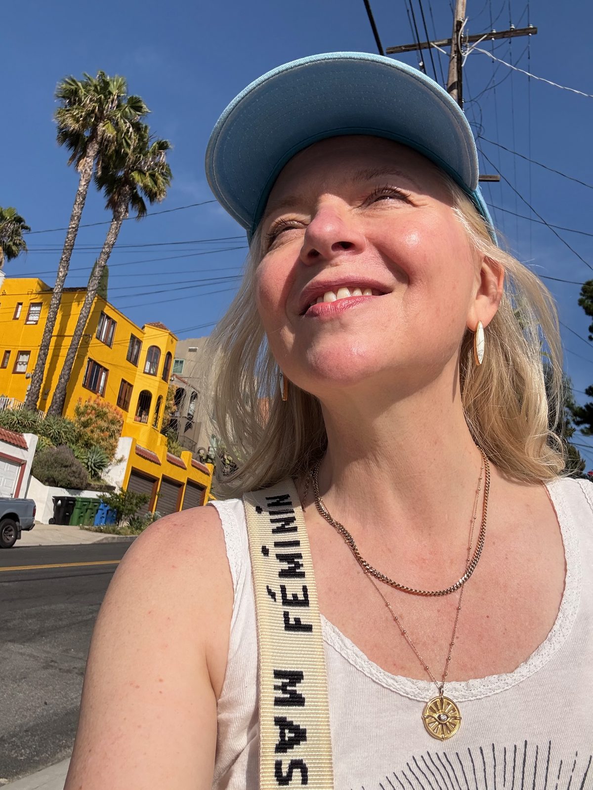 Maggie Langrick in Los Angeles, in a blue cap and white tank top